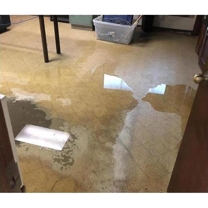 Water damaged flooring with puddles of water.