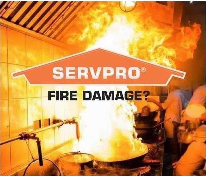 A kitchen on fire from a stove, with SERVPRO logo across the front. 